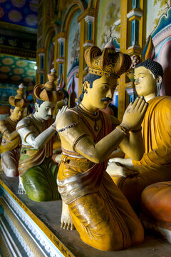 A ray of sunshine lights human statues worshipping Buddha in the Image House at Wewurukannala Vihara at Dickwella in Sri Lanka.