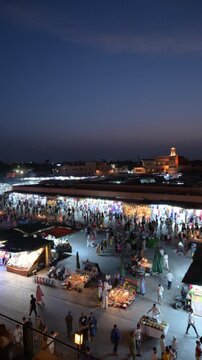 Marrakech, morocco. August 9, 2026. Elevated night view of the bustling jemaa el fnaa square in marrakech, morocco. People are walking among illuminated food stalls