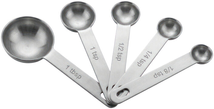 Five stainless steel measuring spoons on black surface.