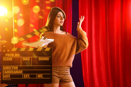 Acting audition and casting call, young woman practicing lines with script on film set with clapperboard and red curtains