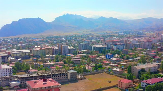 Drone flies backward above a city in eastern Turkey, revealing residential districts, broad streets and surrounding mountains for urban geography, regional tourism, property and planning media.