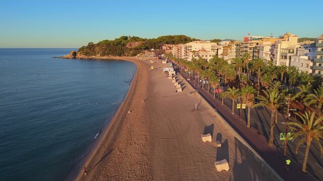 Aerial view taken from a drone of the coast of Lloret de Mar, Costa Brava, Spain, early in the morning at sunrise - the sea, beach and coastal hotels