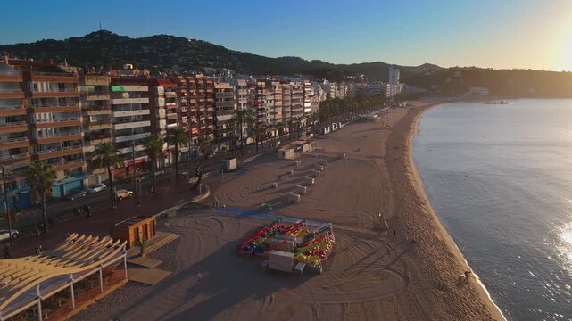 Aerial view taken from a drone of the coast of Lloret de Mar, Costa Brava, Spain, early in the morning at sunrise - the sea, beach and coastal hotels