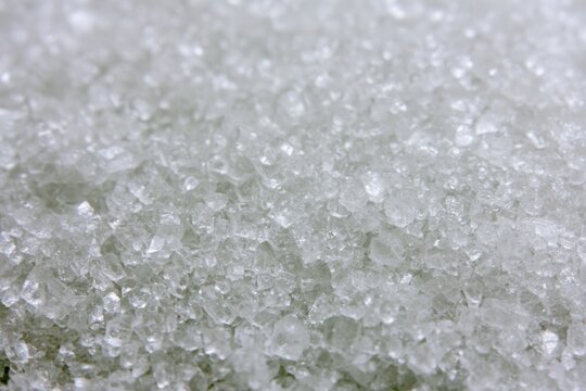 Close-up view of granulated sugar texture on a flat surface during daylight