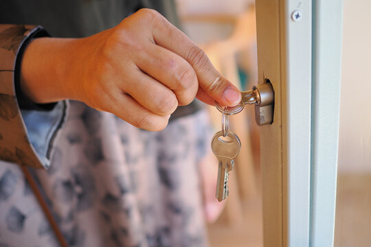 Hand inserting key into door lock at home