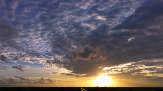 Gray cloud hovering in the middle of a golden sunset sky