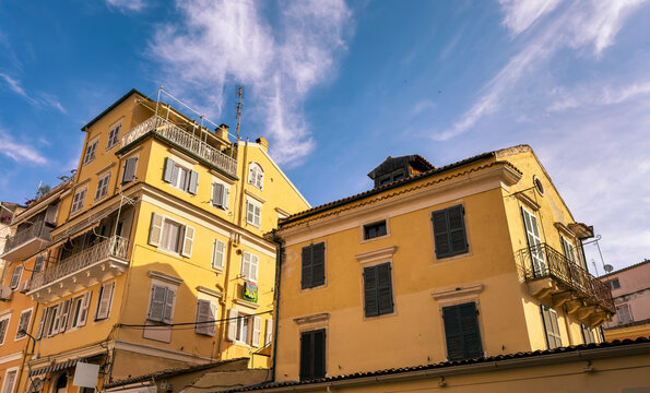 Yellow historic buildings with shutters and iron balconies on Corfu Old Town street, Greece
