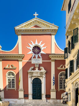 Coral church facade over narrow street in Corfu Old Town, Corfu Island, Greece