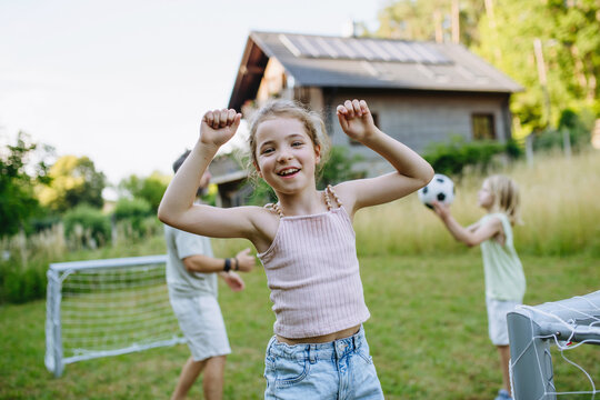 Girl enjoying football game outdoors during summer afternoon.