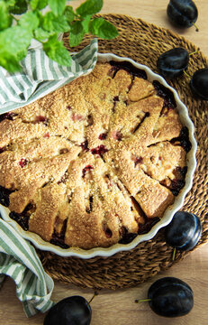 Baked plum dessert with crumb topping on rustic table