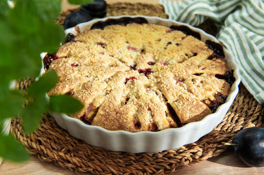 Baked plum dessert with crumb topping on rustic table