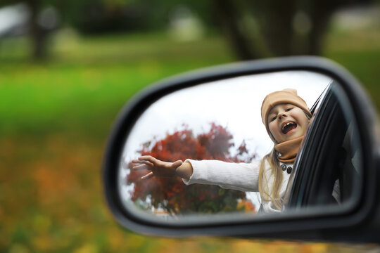 Joyful Child Enjoying Autumn Ride Reflected in Car Side Mirror
