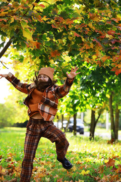 Joyful Girl Playing in Autumn Leaves Wearing Orange and Brown Plaid Outfit