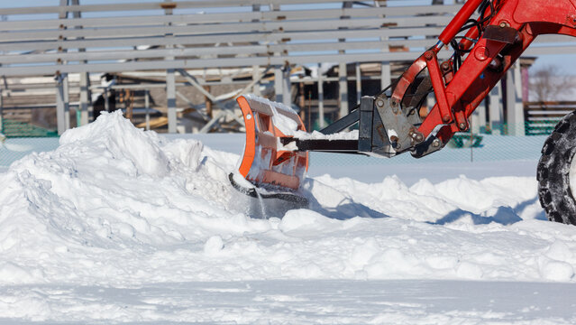 Snow plow clears snow from icy ground