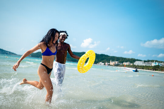 Interracial couple enjoying a romantic beach getaway, embracing love, laughter, and togetherness