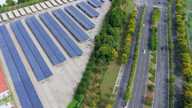 Oblique aerial view of solar parking beside urban road traffic