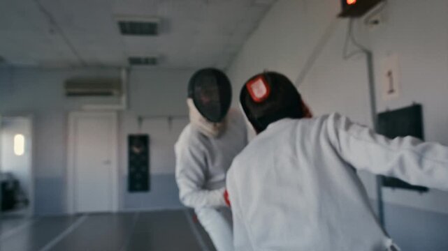 Fencing sport. Sportsmen fencing training. Two swordsmen are doing sword moves. Fencer players in gym, indoor sports club. Two athletes practice epee, uniforms and masks. Olympic combat sport.