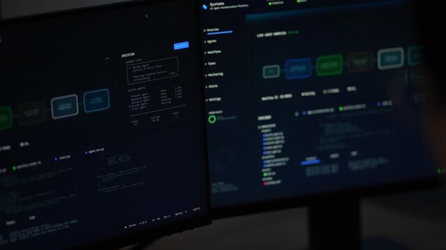 A pair of desktop monitors in a darkened lab display an AI agent workflow canvas beside a running Python terminal as a silhouette passes the frame edge, shot in low light.