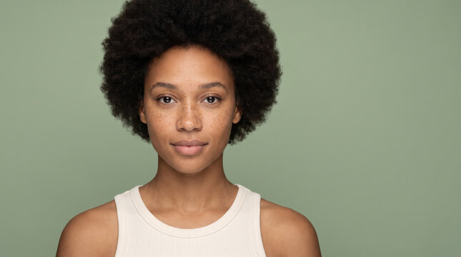 Serene young woman with freckles and natural afro hair portrait