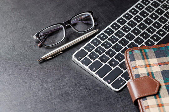 Office supplies on dark leather desk