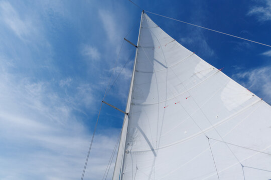White sail against blue sky on sailing yacht