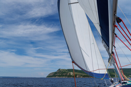 White sail against blue sky on sailing yacht