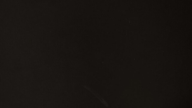 Woman sticking a yellow note with a smiling face on a black wall, symbolizing joy, positive emotions, emotional well-being, psychological health and a positive mindset.