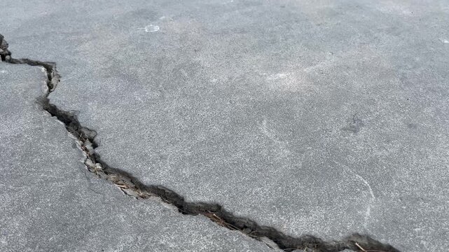 Deep crack on concrete ground surface texture close up