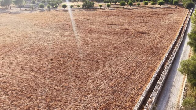 Drought and climate change impact aerial view of dry parched agricultural farmland with arid soil drone shot of desertification in rural landscape