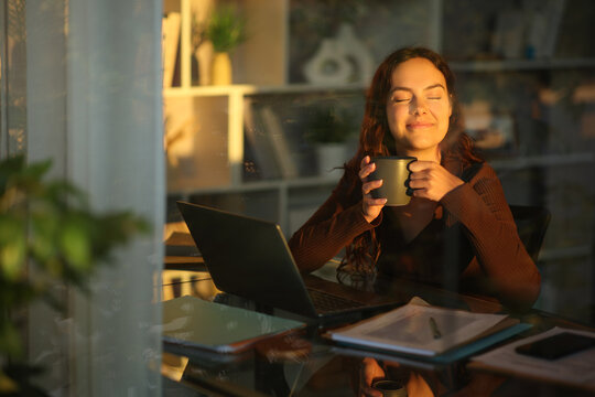 Telecommuter smelling coffee taking a break at home