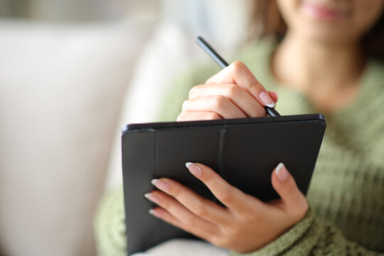 Woman hands handwriting on digital tablet at home