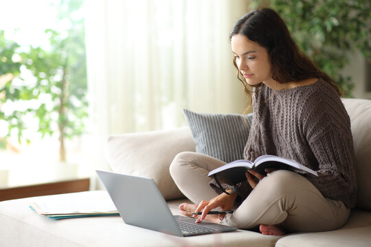 Young telecommuter using laptop and paper agenda on a couch