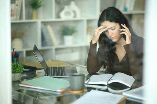 Worried telecommuter checking agenda talking on phone