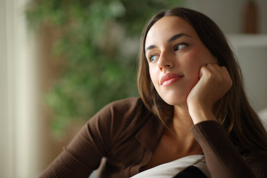 Woman thinking at home looking away