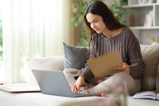 Young telecommuter working online holding folder at home