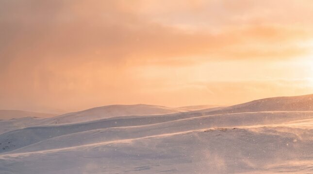 Snow covered rolling hills illuminated by golden sunset light with silhouette background