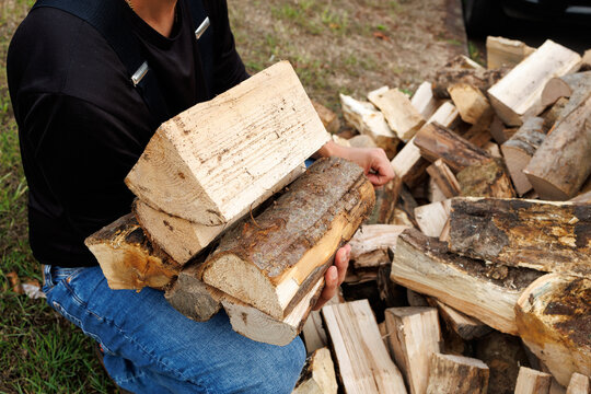 Young Man Carrying Firewood to Storage, Preparing for Winter