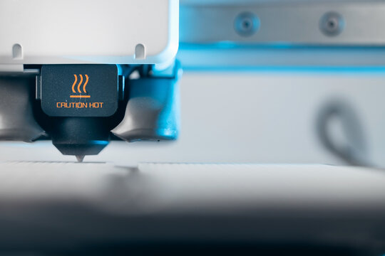 Extreme macro shot of 3D printer nozzle printing white plastic object