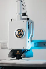 Extreme macro shot of 3D printer nozzle printing white plastic object © Alexander