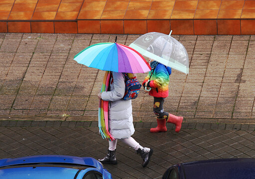 Paraguas, katiuskas y bufanda multicolor lluvia sombrilla de agua de colores madre e hija lloviendo d&iacute;a de lluvia, abrigo chubasquero, botas de agua y suelo mojado 