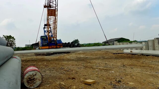 moving corrugated concrete sheet pile using crawler crane on site construction
