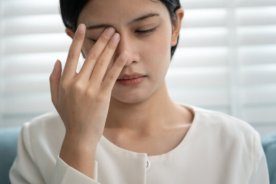 Eye problems, Asian women massage eye for relax, eye rubbing, dry, eye pain after work, migraine, headache, blurred vision, photophobia, working in the dark, blue light from computer screens