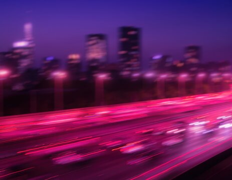 Motion blur of city traffic lights on a highway at night with skyscrapers in the background