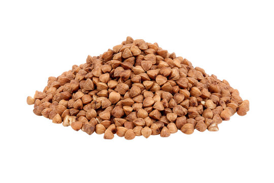 Large pile of raw, light brown buckwheat groats is neatly arranged against a clean white background, captured with bright studio lighting