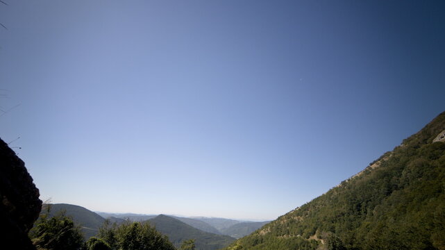 Paesaggio montano con ampio cielo blu limpido e valli verdi