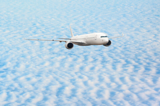 White passenger airplane flying in the sky amazing clouds in the background - Travel by air transport