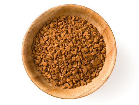 Freeze dried coffee powder in a wooden bowl, isolated on white background, top view.