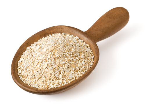 Raw oat bran in the wooden spoon, isolated on white background.