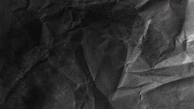 Abstract dark black textured surface with subtle folds and shadows.