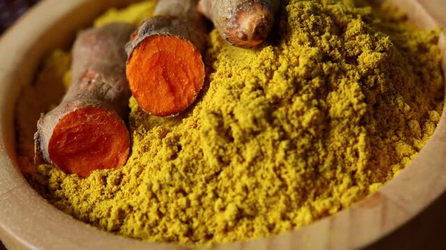Fresh turmeric rhizomes and finely ground turmeric powder arranged together in a bowl
